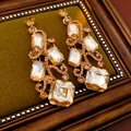 Dettaglio di orecchini vintage dorati quadrati con cristalli su fondo in velluto verde - Marrone Champagne (Perno in Argento S925)