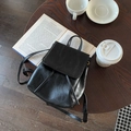 Détail d'un sac à dos minimaliste en cuir noir avec cordon sur une table en bois rustique - Noir Vintage