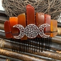 Handmade orange raw crystal hair comb featuring a silver triple moon goddess ornament - Red Agate Black Wire Silver Moon