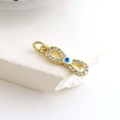 Macro detail of infinity evil eye charm featuring gold plating and white zircon crystals - Full Diamond Infinity Eye