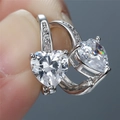 Macro shot of silver earrings featuring large heart-cut cubic zirconia in claw settings - White Gold With White Zirconia