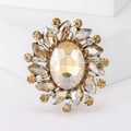 Vintage sunburst brooch featuring a large amber crystal center and gold-tone petals - Champagne