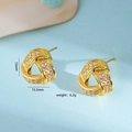 Elegante 15mm gouden knoopoorbellen met zirkonia op lichtblauwe achtergrond - Stud oorbellen / Goud