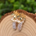 Elegant gold flower earrings with small clusters and long baroque pearls on wood - Lotus Baroque Pearl Dangle Earrings