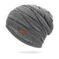 Détail du bonnet en tricot gris avec doublure en peluche et étiquette logo en cuir - Taille unique / Gris