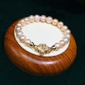 Pink champagne pearl bracelet with golden camellia diamond buckle on wood stand - One Size / Pink