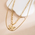 Détail d'un collier double épaisseur doré avec un pendentif papillon raffiné et élégant - Collier Multicouche Doré Pendentif Papillon