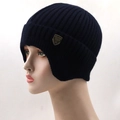 Detail of navy knit beanie featuring vertical ribbing and a vintage shield metal badge - Navy Blue