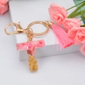 Pink resin letter T keychain with gold foil flakes and matching pink tassel accessory - Letter T