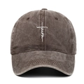 Detailed close-up of white faith embroidery and cross on brown washed cotton baseball cap - Coffee