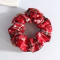 Close-up of red Christmas plush scrunchie with white snowflake patterns and plaid lines - Red Snowflake Green Stripe