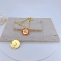 Macro shot of gold-plated celestial pendant with red enamel and zircon moon detail - Red Zodiac Moon Star