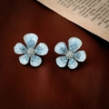Dettaglio di orecchini a fiore in cristallo blu ghiaccio su velluto rosso scuro - Perno in Argento - Orecchini a Bottone con Fiore in Cristallo Blu Chiaro