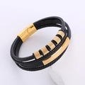 Dettaglio del bracciale multistrato in pelle nera da uomo con chiusura magnetica dorata su pietra - Oro