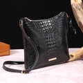 Elegant black crocodile pattern crossbody bag with golden hardware on marble surface - Black