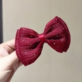 Detail of red mesh bow hair clip with silver glitter accents on a satin fabric base - Burgundy