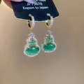 Detail of 14k gold plated gourd earrings with emerald green stones and zircon accents - Green