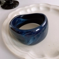 Detailed view of wide resin bangle with dark blue marble texture on white plate - 29# Bangle-Blue-Irregular