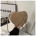 Détail du sac en cuir kaki en forme de cœur avec clous argentés et boucle métallique - Kaki