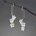 Orecchini a sospensione con tre fiori in argento S925 spazzolato e dettagli oro 18K - Argento