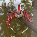 Detailed shot of red raw crystal crown with silver crescent moon moon on a branch - Red