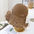 Detail of hand-woven straw hat featuring white lace ribbons and small cherry ornaments - Khaki