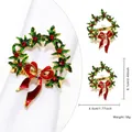 Golden Christmas wreath napkin ring with green leaves, red bow, and rhinestones - Christmas Wreath Style 86