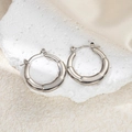 Detailed view of silver bamboo-style stainless steel hoop earrings on a textured stone - O-Shape Bamboo Earrings (0185)