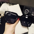 Close-up of black oversized square sunglasses with a white textured leather protective case - Black