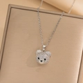 Macro shot of silver teddy bear pendant with sparkling cubic zirconia pavé and fine chain - Bear Necklace / Steel