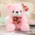 Ours en peluche rose avec bonnet de Noël rayé et écharpe assortie dans un décor chaleureux - Style D Écharpe à rayures tricolores / Rose