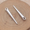 Polished silver spike pendant bead for jewelry making on a rustic wooden tray - White Gold