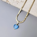 Detail van 18K vergulde slangenketting met een diepblauwe hartvormige kattenoogsteen hanger - Blauw hart