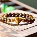 Tiger eye stone beaded bracelet featuring a heart-shaped charm on a natural wood surface - Heart Pendant / Yellow-Brown (Tiger Eye)