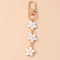 Dettaglio del portachiavi a fiori di ciliegio dorati con smalto bianco e chiusura a moschettone - Chiusura ad Anello / Bianco
