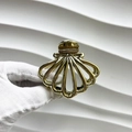 Detailed view of a gold-plated shell-shaped metal hair claw clip with elegant hollow design - Shell Style / Gold