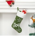 Dettaglio calza di Natale verde con bordo in pelliccia sintetica bianca e ricamo Joy - JOY