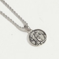 Detail of vintage silver round pendant featuring embossed castle and star on rope chain - Castle Relief