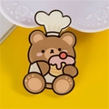 Cute brown chef bear enamel pin with cupcake detail on a bright yellow background - Bear with Cake