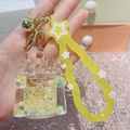 Macro shot of liquid quicksand keychain with yellow stars in a clear castle bottle - Castle Yellow