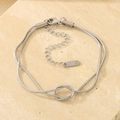 Detailed macro view of silver stainless steel double-layered knot chain bracelet on stone - Silver Knot Snake Chain Bracelet Style (KB185288-Z)