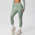 Detail view of sage green high-waisted yoga leggings with matte professional fabric texture - 7100 Trousers - Basil Green / S