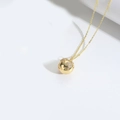Golden globe pendant necklace featuring white cubic zirconia inlays on a fine link chain - Globe / Gold