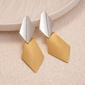 Dettaglio di orecchini geometrici con finitura argento lucido e texture oro spazzolato - Argento Lucido e Oro Spazzolato