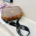 Detail of latte leather camera bag with litchi texture and orange wave strap design - Khaki (Brown Strap)