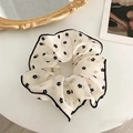 Detailaufnahme von cremefarbenem Haargummi mit Blumenmuster und gewelltem Saum - Floral Scrunchie