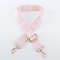 Detail eines pink-weißen Jacquard-Taschenriemens mit goldenen Karabinerverschlüssen - Leichtgold-Schnalle / Rosa