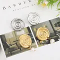 Dettaglio di orecchini a spirale argento e dorati con perle su una rivista d'arte - Oro EH004 (Disco di Perla)