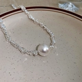 Detail of silver irregular bead necklace with a large round white pearl on ceramic plate - Silver Metal Bead Big Pearl Style