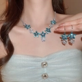 Close-up of blue zircon flower pendant necklace and earrings set on elegant female model - 93# Necklace-Silver-Blue